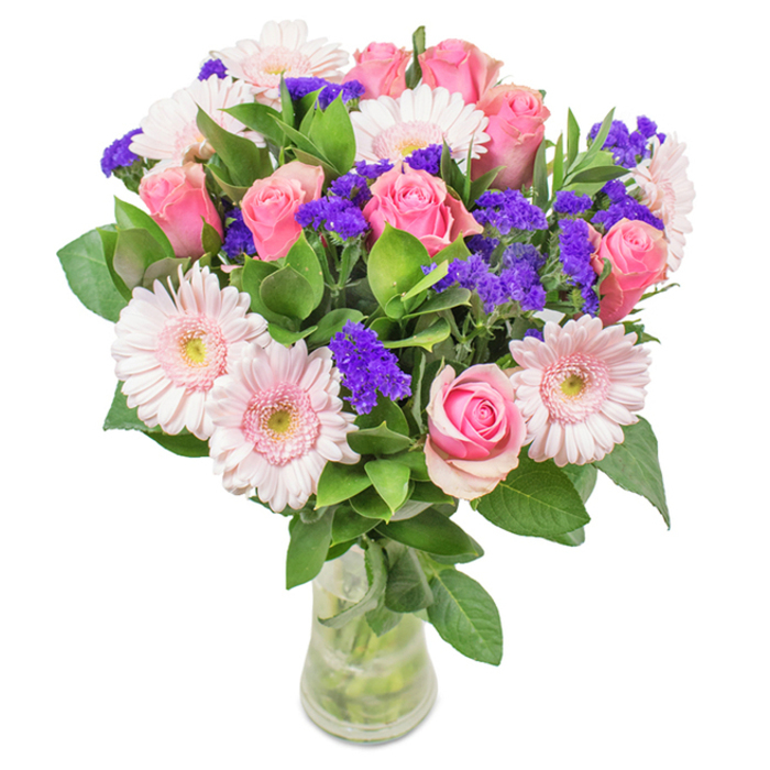 This elegant arrangement-a classic highlight in West Ham's local flower scene-is exquisitely presented in a clear, slender glass vase against a soft white background. Its heart features seven to nine velvety pink roses, petals delicately curled from bud to bloom, conveying both tenderness and celebration. Intertwined are five to seven pale pink gerbera daisies, their broad, radiant petals and near-white centres creating a light, airy feel. Dotted throughout are vibrant clusters of deep purple statice, their papery blooms adding energizing pops of colour and engaging texture. Lush green foliage underpins the bouquet, offering fullness and an invigorating freshness akin to West Ham's parks and riverside walks. The arrangement's visible stems and pristine water hint at its immediate freshness, perfect for a birthday surprise, anniversary, or Mother's Day gesture in West Ham, or as a beautiful accent in any home or office. Every aspect of this bouquet is designed to convey happiness, gratitude, and thoughtful affection within the local community.
