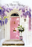 In this photograph, a charming entrance in West Ham becomes a gentle portrait of new beginnings. The central feature is a pastel pink front door, its surface smooth and even, painted in a tone that manages to be both cheerful and soothing. The surrounding wall is whitewashed, lending a clean, airy backdrop that reflects the natural light, while a single blush-coloured shutter on one side extends the soft palette and suggests a cosy interior beyond the glass. Flowing from above, generous strands of wisteria drape themselves over the doorway, their blossoms a mist of lavender, lilac, and pale purple. Each hanging cluster curves naturally, creating an overhead canopy that feels almost like a floral curtain, the kind of detail you might notice on a quiet evening walk through West Ham's residential streets when the air is cool and scented with spring. Resting neatly on the doorstep is a grey metal bucket, sturdy yet refined, filled to the brim with creamy white roses and gentle greenery. The roses are full and rounded, with tightly layered petals unfurling into softly ruffled edges, giving the arrangement a plush, romantic feel. Between them, hints of fresh green foliage add movement and subtle contrast, as though leaves from a nearby garden have found their way into the composition. A delicate pink ribbon encircles the bucket and is tied in a small bow, its soft sheen catching the light and linking the flowers to the door's inviting hue. Together, these elements create a scene that feels like a thoughtful housewarming gift, perhaps delivered by Florist West Ham to celebrate a new home-filled with warmth, optimism, and the quiet, fragrant assurance that this is where treasured memories will soon begin.